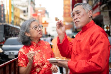 Mutlu bir çift, Bangkok, Tayland 'da Çin Mahallesi' nde el ele tutuşup, gezmekten, seyahat etmekten ve atıştırmalık yemekten zevk alır.