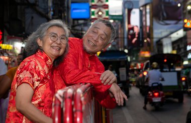 Mutlu bir çift, Bangkok, Tayland 'da Çin Mahallesi' nde el ele tutuşup, gezmekten, seyahat etmekten ve atıştırmalık yemekten zevk alır.