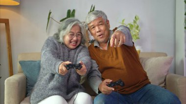 Büyükanne ve büyükbabalar evlerinin rahat oturma odasında oyun oynuyorlar.