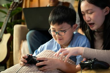 Torunlarıyla rahat bir oturma odasında video oyunu oynayan mutlu büyükanne ve büyükbaba.