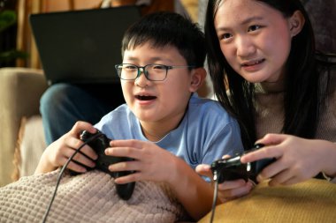 Torunlarıyla rahat bir oturma odasında video oyunu oynayan mutlu büyükanne ve büyükbaba.