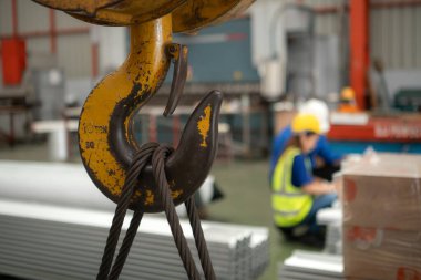 Kıdemli mühendisler ve genç bayan işçiler fabrikadaki üretim hattına gönderilmeden önce çok amaçlı oluşumlar için çelik levhaları konuşuyor ve inceliyorlar.