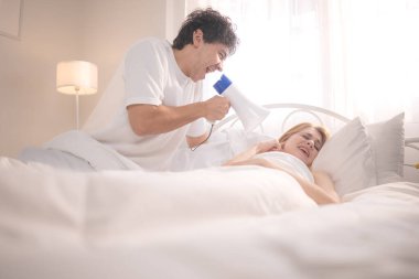 Sabahları ortağını uyandırmak için megafon kullanan oyuncu. O da kulaklarını yatakta kapatıyor.