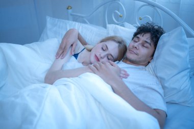 Sevgi dolu bir çift gece yatakta barışçıl bir şekilde sarılıp sıcaklığını, sevgisini ve duygusal bağını belli ediyor.