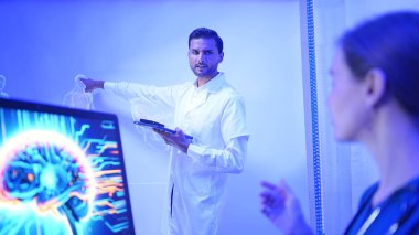 Doktorlar ve tıp uzmanları modern bir hastane ortamında fiziksel ve beyin hazırlıklarını fütüristik hologram teknolojisiyle tartıştılar.