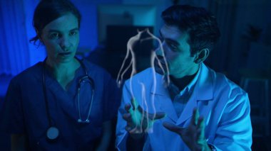 Doktorlar ve tıp uzmanları modern bir hastane ortamında fiziksel ve beyin hazırlıklarını fütüristik hologram teknolojisiyle tartıştılar.