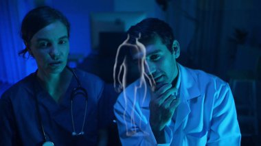 Doktorlar ve tıp uzmanları modern bir hastane ortamında fiziksel ve beyin hazırlıklarını fütüristik hologram teknolojisiyle tartıştılar.