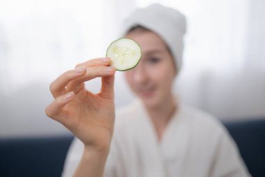 Salatalık gibi doğal cilt bakımı aktiviteleri olan genç bir kadın.