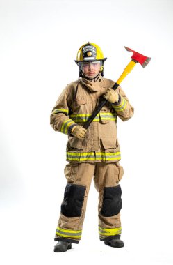 Tam donanımlı bir itfaiyeci, beyaz bir arka plana karşı bir kurtarma baltası ile güvenle ayakta duruyor.