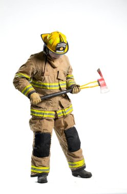 Tam donanımlı bir itfaiyeci, beyaz bir arka plana karşı bir kurtarma baltası ile güvenle ayakta duruyor.