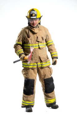 Tam donanımlı bir itfaiyeci, beyaz bir arka plana karşı bir kurtarma baltası ile güvenle ayakta duruyor.