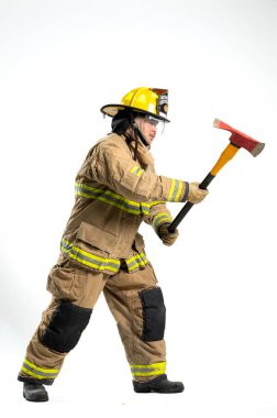 Tam donanımlı bir itfaiyeci, beyaz bir arka plana karşı bir kurtarma baltası ile güvenle ayakta duruyor.