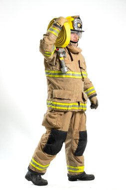 İtfaiye hortumu ve yangın hortumu tutan koruyucu üniformalı bir itfaiyecinin tüm vücut portresi. Bireyler, beyaz bir arka plana karşı güvenle dururlar.