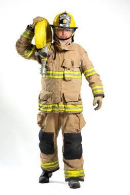 İtfaiye hortumu ve yangın hortumu tutan koruyucu üniformalı bir itfaiyecinin tüm vücut portresi. Bireyler, beyaz bir arka plana karşı güvenle dururlar.
