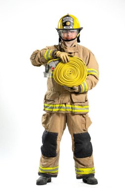 İtfaiye hortumu ve yangın hortumu tutan koruyucu üniformalı bir itfaiyecinin tüm vücut portresi. Bireyler, beyaz bir arka plana karşı güvenle dururlar.