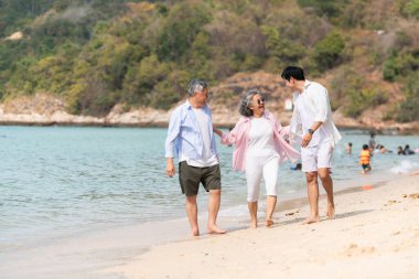 Tatilde, kıyı şeridi boyunca oğluyla yürüyen kıdemli çift gün içinde sahilde konuşurken...