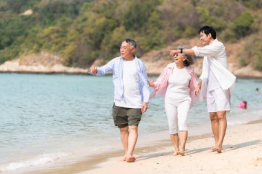 Tatilde, kıyı şeridi boyunca oğluyla yürüyen kıdemli çift gün içinde sahilde konuşurken...