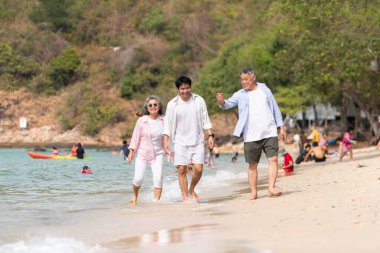 Tatilde, kıyı şeridi boyunca oğluyla yürüyen kıdemli çift gün içinde sahilde konuşurken...