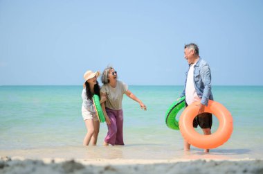 Tatilde, aile fertleri sığ deniz suyunda durur ve gündüz vakti kumsalda birbirlerine şişme yüzükler dağıtırlar.