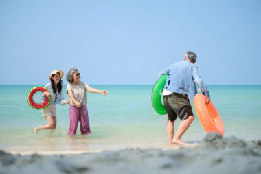 Tatilde, aile fertleri sığ deniz suyunda durur ve gündüz vakti kumsalda birbirlerine şişme yüzükler dağıtırlar.