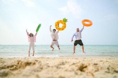 Tatilde, aile üyeleri gün içinde deniz kenarında dururken havaya şişirilebilir yüzükler fırlatıp zıplıyorlar.