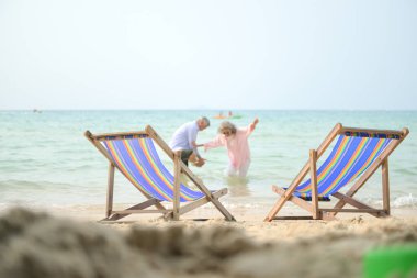 Tatilleri boyunca, kıdemli çift gün içinde deniz kenarındaki plaj sandalyelerinde dinlenmeyi severler.