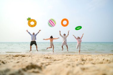 Tatilde, aile üyeleri gün içinde deniz kenarında dururken havaya şişirilebilir yüzükler fırlatıp zıplıyorlar.