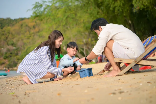 Tatilde, ebeveynler plaj sandalyelerinde oturup, gün boyunca çocuklarının kumsalda kum oyuncaklarıyla oynamasını seyrederler.