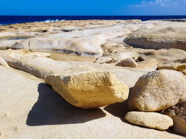 Maltas kıyı şeridinde, parlak bir gökyüzünün altında ufka uzanan parlak Akdeniz 'e doğru uzanan rüzgar ve dalgalarla oyulmuş kireçtaşı uçurumları ve berrak kaya havuzları yer alıyor..