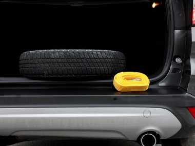 Sarı halat ve yedek lastik kurtarma ve yol yardımı için bir arabanın bagajında kalın. Profesyonel kurtarma ekipmanları, sürücülerin uzun yolculuklarda beklenmedik araç arızalarıyla başa çıkmalarına yardımcı olur..