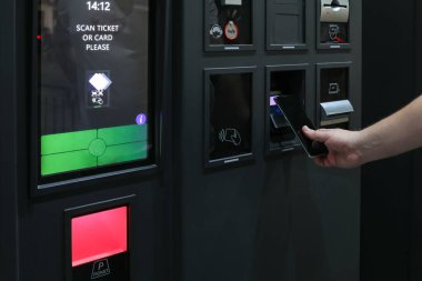 Otomatik hizmet makinesinde temassız mobil park ödemesi, otomatik park terminalinde NFC akıllı telefon taraması, dijital nakitsiz işlem, akıllı şehir ulaşım teknolojisi.