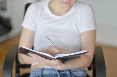 Beyaz bir T-shirt bir defter ve kalem ile kız.