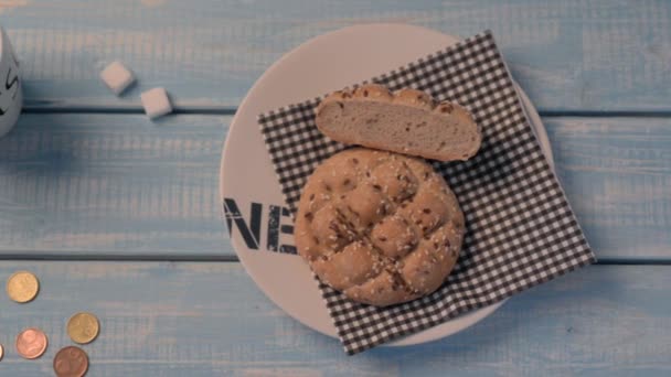 Roti Inexpensive, secangkir kopi dan dua potong gula di atas meja kayu biru. Biaya minimum . — Stok Video