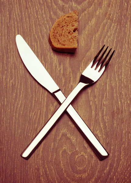 Couteau et fourchette haut de gamme. Une tranche de pain. La fin . — Photo