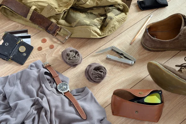 Des vêtements et accessoires de couleur sable reposent sur le sol en bois . — Photo