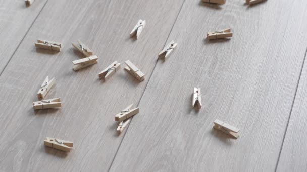 Küçük ahşap clothespins güzel bir ahşap zemin döktüm. Düşen küçük ahşap clothespins arkadan aydınlatmalı. Ters. — Stok video