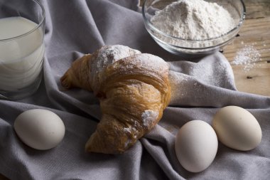 Ay çöreği, yumurta, süt ve un natürmort. Rustik tarzı.