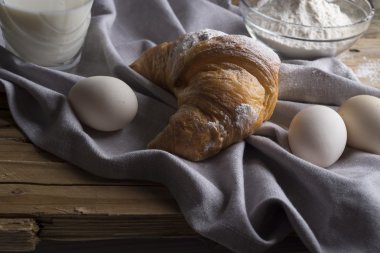 Ay çöreği, yumurta, süt ve un natürmort. Rustik tarzı.