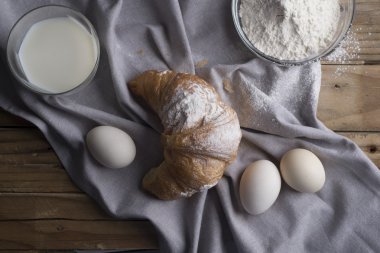 Ay çöreği, yumurta, süt ve un natürmort. Rustik tarzı.