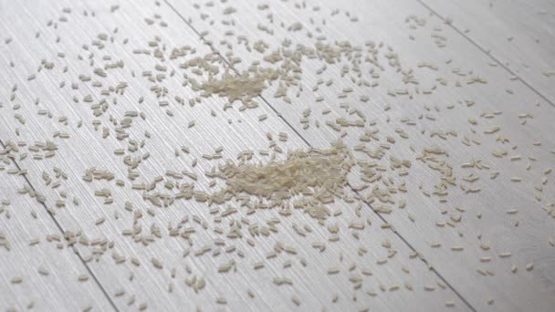Kruimelig rijst gemorst op een mooie houten vloer. Dalende rijst verlicht. Omgekeerde. — Stockvideo