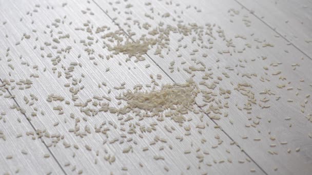 Crumbly rice spilled on a beautiful wooden floor. Falling rice backlit. Reverse. — Stock Footage Crumbly rice spilled on a beautiful wooden floor. Falling rice backlit. Reverse. Video Clip