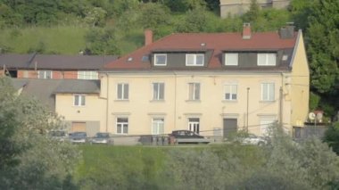 Güneşlikler aracılığıyla sarı bir retro ev üstünde belgili tanımlık pencere görünümünden. Ken Burns efekti.