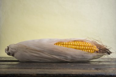 Olgun sarı Mısır karanlık eski ahşap bir masa üzerinde. Ülke stil.