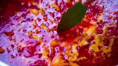 Borsch. defne yaprağı ekle. Geleneksel Rus çorbası, Ukrayna çorbası Borsch yakın plan. Sebzeli, etli ve baharatlı kırmızı çorba. Borsh için özel kırmızı pancar, havuç ve domatesli makarna. Yüksek kalite 4k görüntü