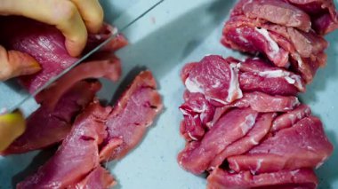 Bir dişi kırmızı et leşini keser. Eti dilimlere ayırıyor. Yüksek kalite 4k görüntü