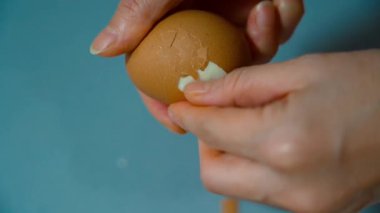 Haşlanmış yumurta soyan Kadın Elleri 'nin yakın çekimi. Yüksek kalite 4k görüntü