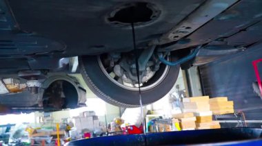 Yağ değişimi sırasında arabanın altındaki eski kirli yağ boşaltılıyor. Araba motorunun alt görüntüsü. Motor yağını değiştiriyorum. Yüksek kalite 4k görüntü