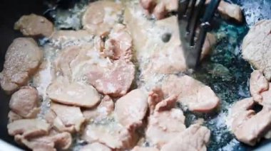 Kızartma tavasında et pişirmek, spatulayla kazımak. Yüksek kalite 4k görüntü