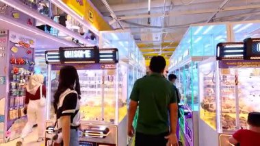 İnsanlar Bandung Alışveriş Merkezi 'nde 10 Ağustos 2025' te arkadaşlarıyla ve aileleriyle hevesle pençe makineleri oynuyorlar..