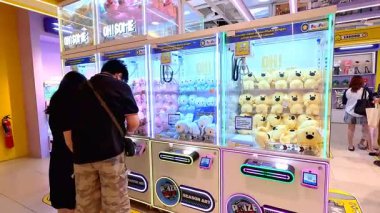 İnsanlar Bandung Alışveriş Merkezi 'nde 10 Ağustos 2025' te arkadaşlarıyla ve aileleriyle hevesle pençe makineleri oynuyorlar..